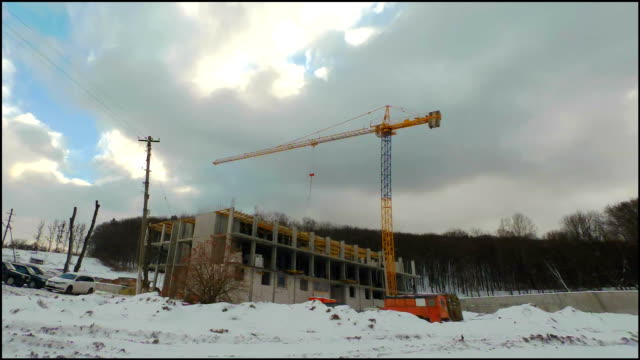 Timelaps-of-winter-construction.-Work-of-cranes-on-construction.-Fast-moving-clouds