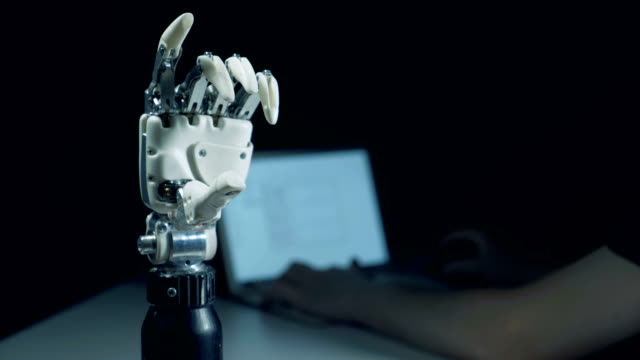 Mover-brazo-robótico-y-un-hombre-que-trabaja-en-un-portátil
