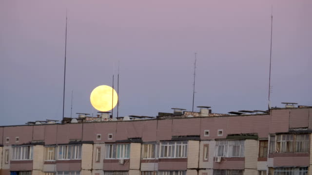 Big-Full-Moon-above-the-Roof-of-a-Multistory-Building-is-moving-up