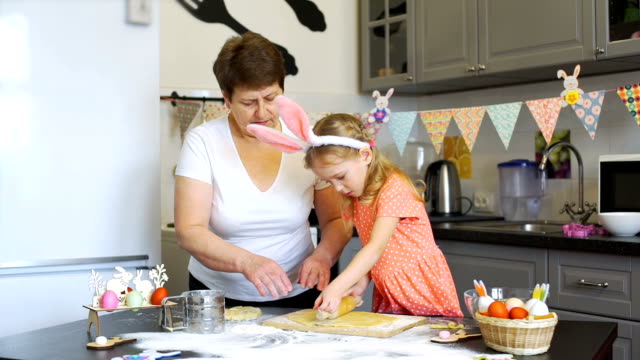 Little-Girl-Rolls-Out-a-Dough-with-Grandmother