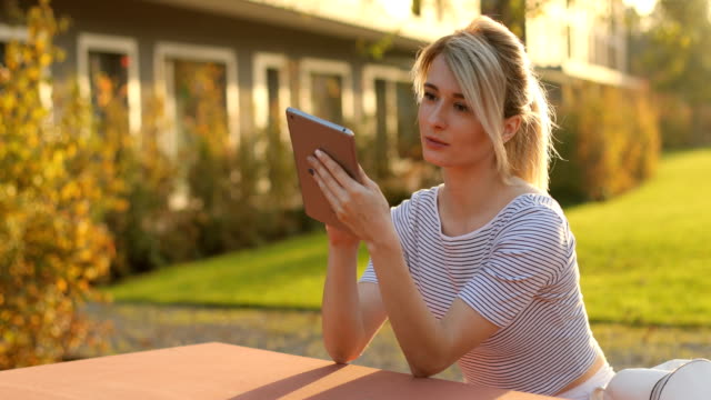 young-beautiful-business-woman-sitting-at-a-table-with-tablet-in-hands