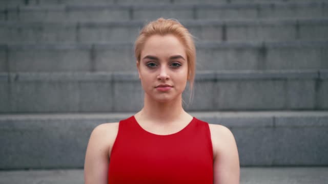 Portrait-of-plus-size-mixed-race-blond-woman-wearing-red-sportswear-looking-at-camera