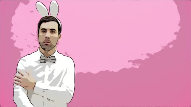 Young-handsome-man-standing-on-a-pink-background.-Dressed-in-a-white-shirt-with-rabbit-ears-on-his-head.-Putting-a-hand-on-the-hand,-serious,-looking-into-the-camera.-Easter-concept.