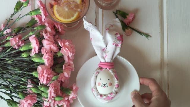 La-mano-femenina-pone-el-plato-con-huevo-de-Pascua-decorado-para-conejo-de-Pascua