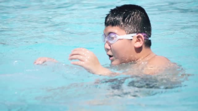 Asiatische-Preteen-Junge-trägt-Brille-und-spielen-im-Pool.