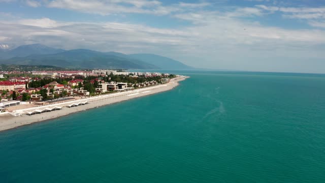 Aerial-video-shooting.-The-black-sea-coast-of-Krasnodar-region,-Sochi.-Imeretinskaya.-Equipped-beach.-Recreation-area.-Panorama-shooting.-Blue-sky.-Clean-sea-water.