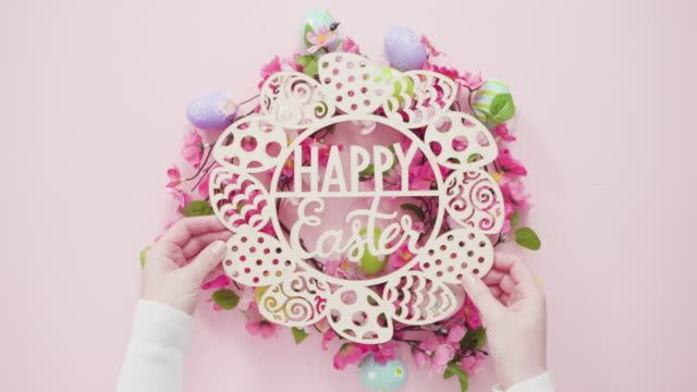 Happy-Easter-sign-and-pink-silk-flowers-on-a-pink-background.