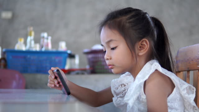 Asien-Mädchen-spielen-Spiel-online-auf-dem-Handy