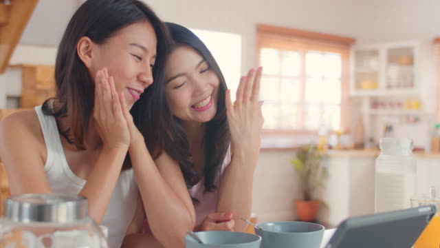 Asiatische-Lesben-Influencer-Paar-mit-Tablet-Aufnahme-Vlog-Video-auf-Social-Media-beim-Frühstück-in-der-Küche.