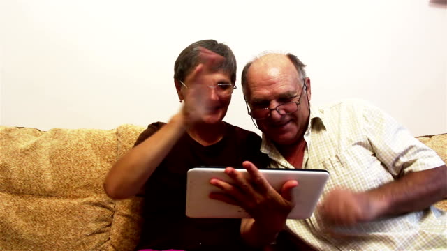 Attractive-adult-woman-and-adult-man-make-a-video-call-with-their-family-on-a-tablet-pc.