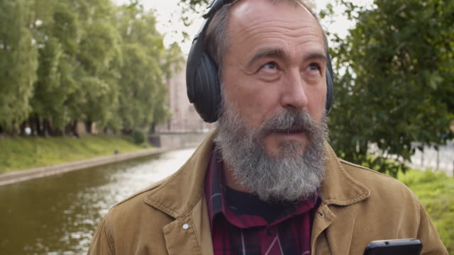 Aged-Man-Listening-to-Music-Outdoors
