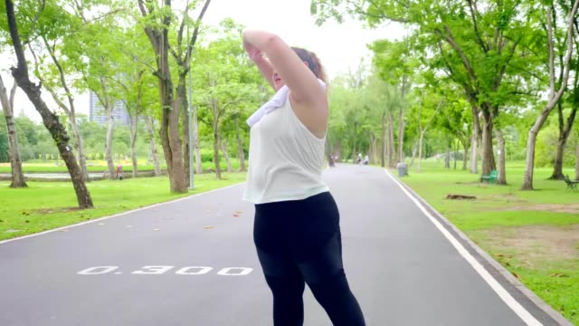 Große-bauen-junge-Frau-trainieren,-um-Gewicht-im-Park-zu-verlieren