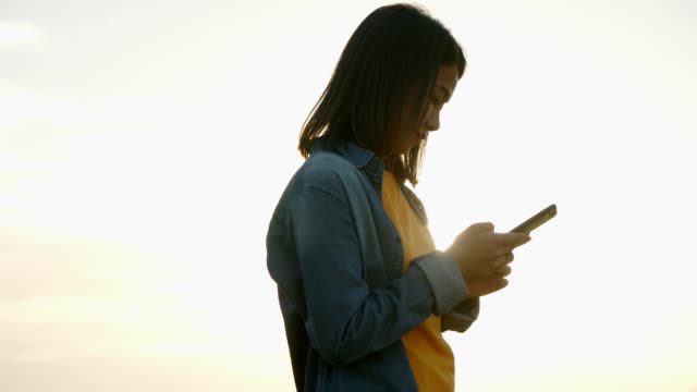 Seitenansicht-aus-nächster-Nähe-Hände-von-attraktiven-jungen-asiatischen-Frau-scrollt-durch-Social-Media-Feed-auf-einem-Smartphone.-Der-Lebensstil-junger-asiatischer-Freunde-reist-urlaubsreisen.