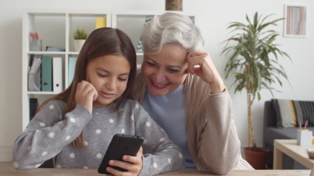Kaukasische-Großmutter-und-Enkelkind-mit-Smartphone