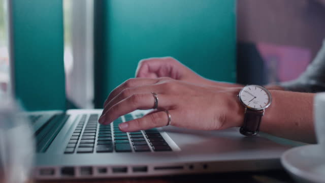 Close-up.-Female-hand-with-a-wristwatch-typing-on-a-laptop-keyboard