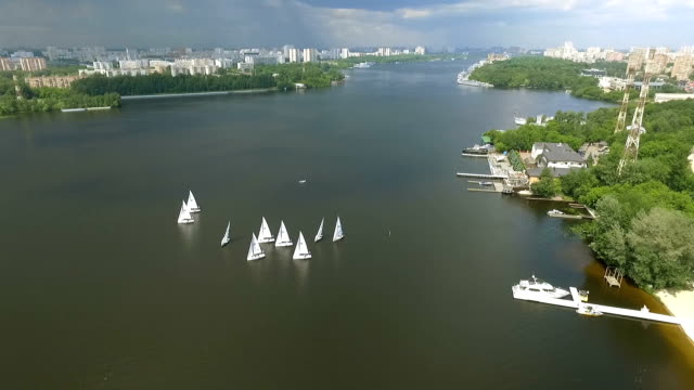 Shooting-bird's-eye.-Flying-drone-slowly-flying-over-blue-water.-Beautiful-hotel-on-the-banks-of-the-river.-Yacht-dock.4k-resolution.-Calm