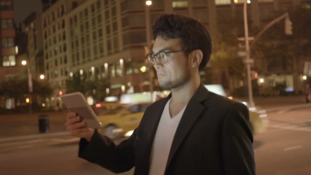 Young-Asian-Man-Using-Tablet-in-Urban-Environment.-Symbolizes-Global-Communication,-Digital-Technology,-Modern-Lifestyle