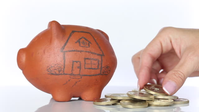Frau-in-einem-traditionellen-Ton-Piggy-Bank-für-ein-Haus-sparen