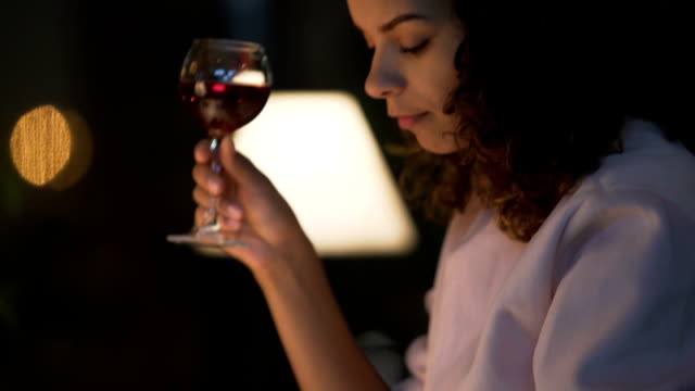 Young-woman-drinking-wine-in-restaurant,-browsing-social-network-on-smartphone