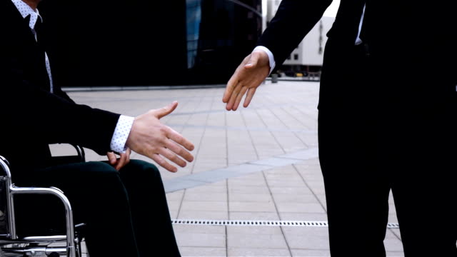 Happy-Entrepreneur-Shaking-Hands-With-Invalid-Businessman-Outdoor