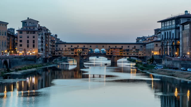 River-Arno-and-famous-bridge-Ponte-Vecchio-day-to-night-timelapse-after-sunset-from-Ponte-alle-Grazie-in-Florence,-Tuscany,-Italy