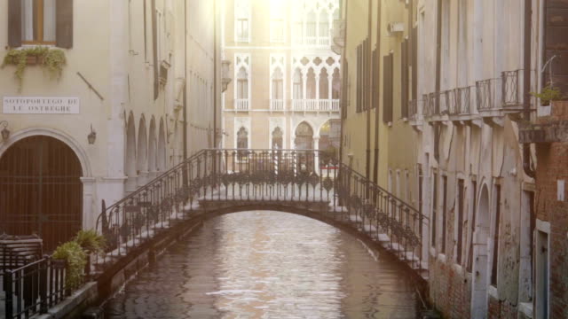 Arch-bridge-between-buildings-over-narrow-channel,-beautiful-architecture-around