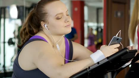 Lazy-fat-girl-pretending-to-work-hard,-scrolling-social-media-on-her-smartphone