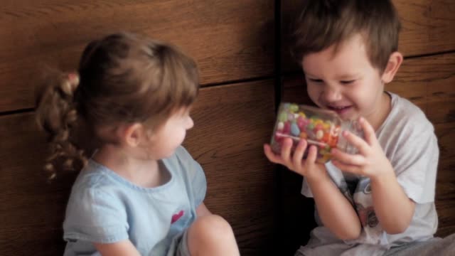 niños-tratando-de-abrir-el-tarro-de-caramelos