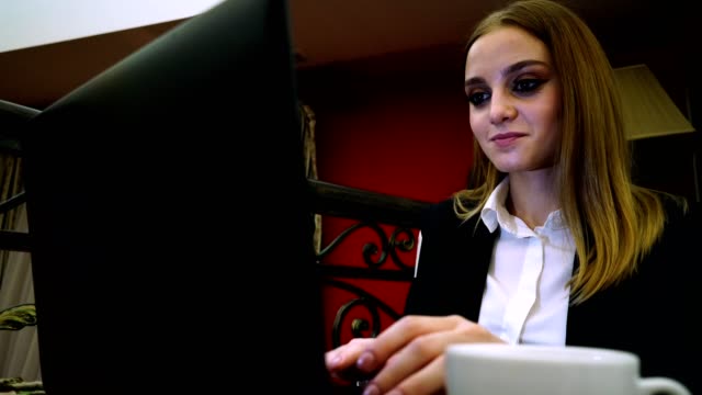 Young-business-lady-sitting-on-a-laptop-is-gaining-text