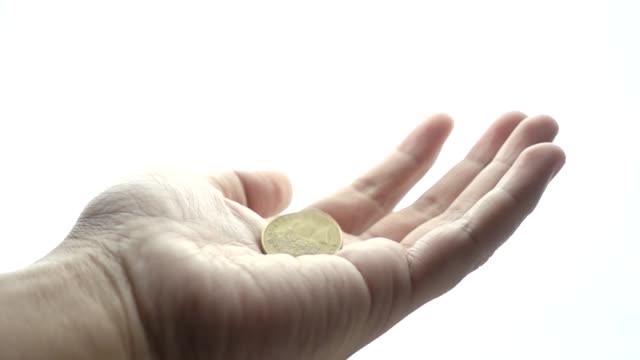 Man-hand-begging-on-a-white-background-with-coin-falling-into-hand-in-slow-motion.-Concepts-and-ideas
