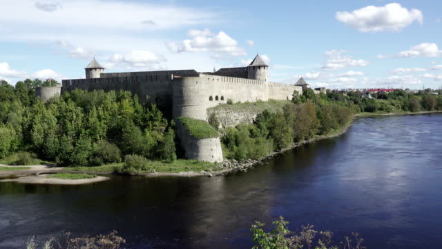 Schöne-Stadtbild,-mittelalterliche-touristische-Attraktion-auf-russisch-estnischen-Grenze-Ivangorod-Festung-am-Ufer-des-Flusses-Narva,-bewölkten-himmelshorizont