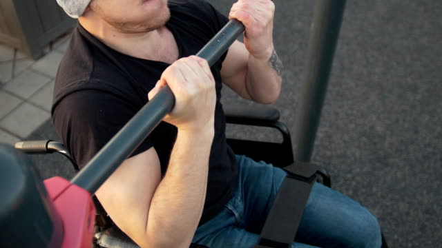 Hombre-con-discapacidad-en-silla-de-ruedas-tira-de-la-barra-al-aire-libre