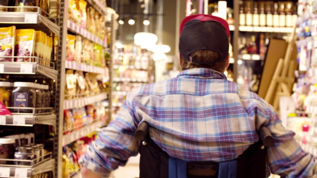 Ein-behinderter-Mann-im-Rollstuhl-im-Supermarkt