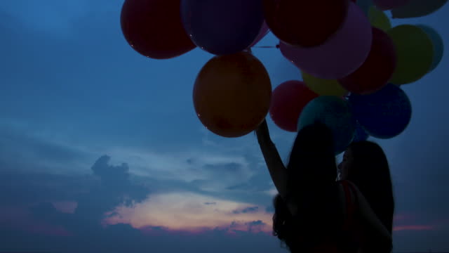 Junges-paar-Leute-halten-Ballon-mit-Sonnenuntergang-Hintergrund-in-Zeitlupe.