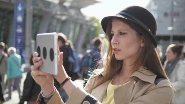 Good-looking-young-female-working-on-digital-tablet-in-public-space-outside