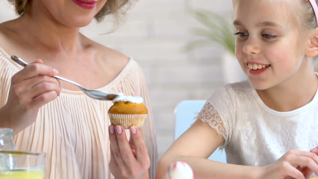 Charming-mother-and-daughter-icing-and-decorating-home-made-Easter-cupcakes