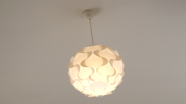 Single-round-decorative-chandelier-with-a-burning-lamp.