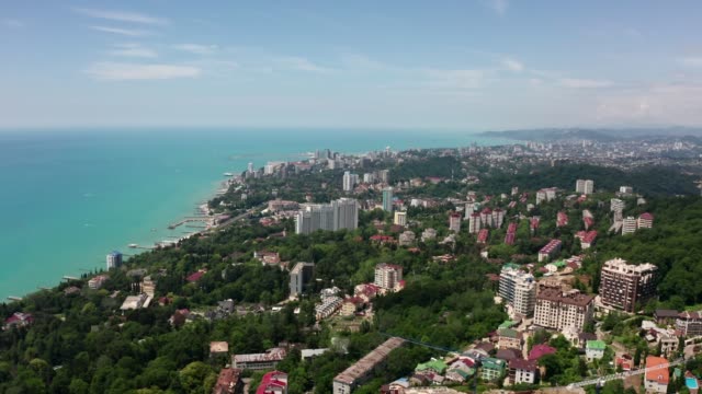 Aerial-video-shooting.-Flying-over-a-residential-area.-The-city-resort-of-Sochi.-Black-sea-coast.-Green-forest-and-mountains-by-the-sea.