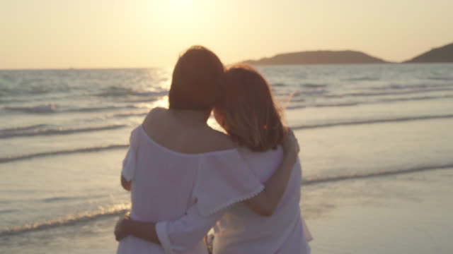 Junges-asiatisches-lesbisches-Paar-küsst-in-der-Nähe-des-Strandes.-Schöne-Frauen-lgbt-Paar-glücklich-entspannen-Sie-Liebe-und-romantische-Moment,-wenn-der-Sonnenuntergang-am-Abend.-Lifestyle-lesbisches-Ehepaar-reist-nach-Strandkonzept