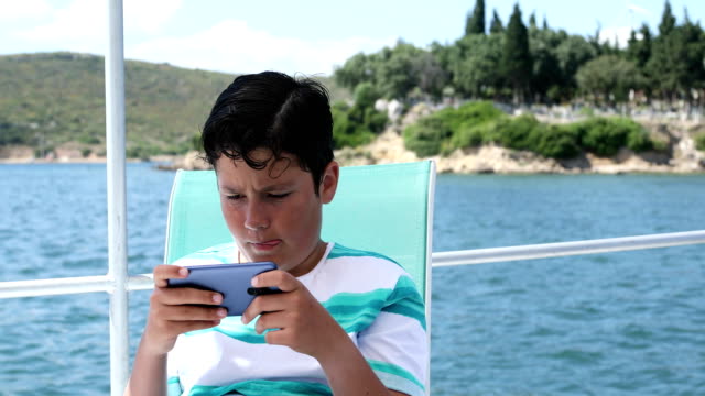 Junge-auf-dem-Boot-mit-dem-Smartphone