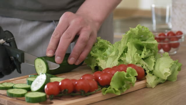 Hombre-con-brazo-biónico-Cortando-verduras-para-ensalada