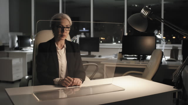 Grey-Haired-Career-Lady-Working-on-Futuristic-Device-with-AR-Touchscreen