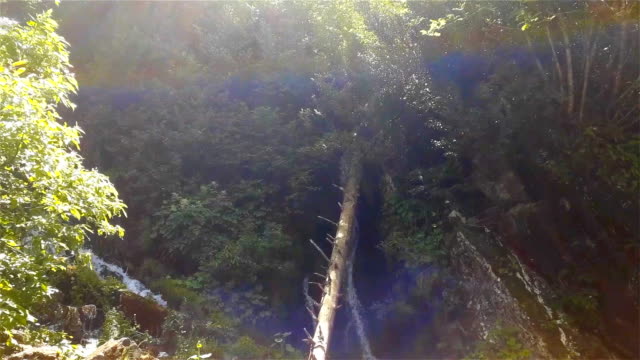 Schöne-frische-Wasserfall-unter-hohen-Felsen-witth-Grün-in-Sotschi,-Russland