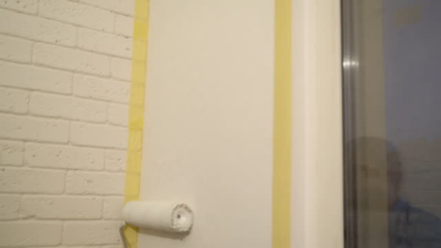 männlicher-Arbeiter-malt-eine-Wand-mit-weißer-Farbe-4K