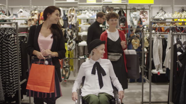 Paraplegiker-Frau-Einkaufen-für-Kleidung-mit-Freunden