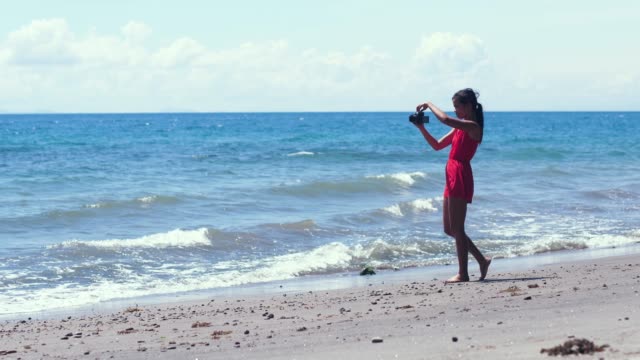Freischaffende-Fotografin-ließ-ihre-DSLR-Kamera-fallen,-während-sie-am-Strand-Fotos-machte.