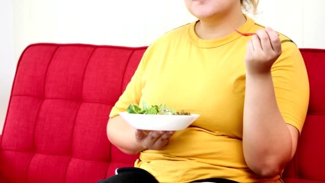 Glückliche-übergewichtige-Frau-genießt-es,-gesundes-Essen-zu-essen
