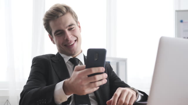 Geschäftsmann-mit-Handy-und-Selfie-im-Büro