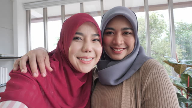 Attractive-two-muslim-business-woman-Take-a-picture-of-yourself,-Selfie-or-videocall-with-Smart-phone