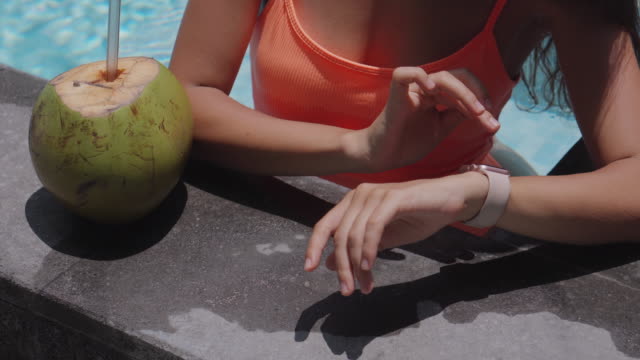Hände-einer-aktiven-jungen-Frau,-die-den-Bildschirm-einer-Smartwatch-im-Pool-berührt